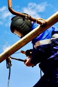 alt="Сварка газопровода специалистом ogs55.ru — монтаж труб на высоте с соблюдением техники безопасности"